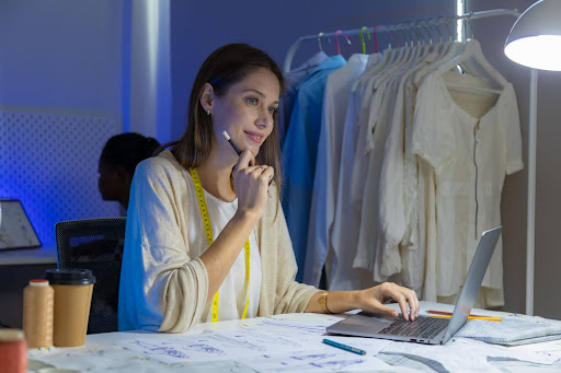 Woman contemplating fashion data in low lighting