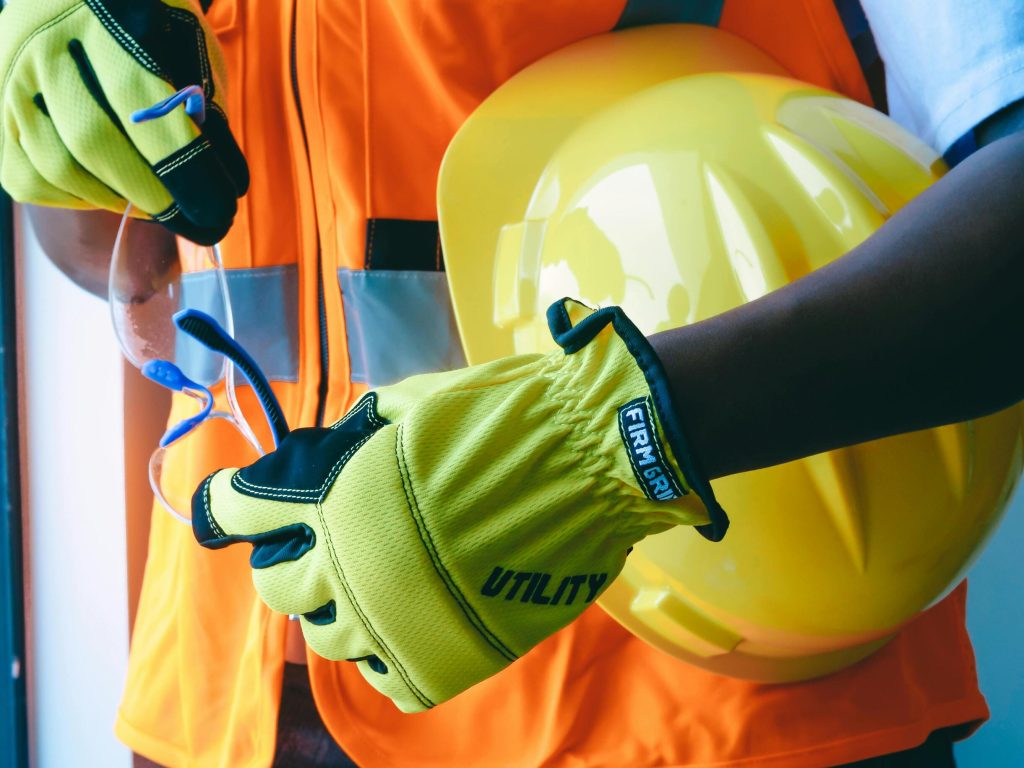 High-visibility workwear including safety gloves and helmet used by manufacturers implementing an erp company for the workwear industry to manage production and inventory.