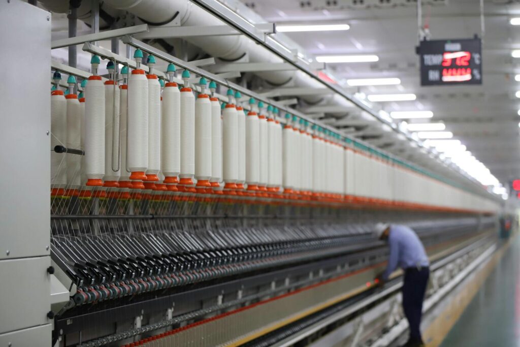 Dyed fabric rolls organized vertically in a textile environment, reflecting roll-level inventory control in textile ERP software systems.