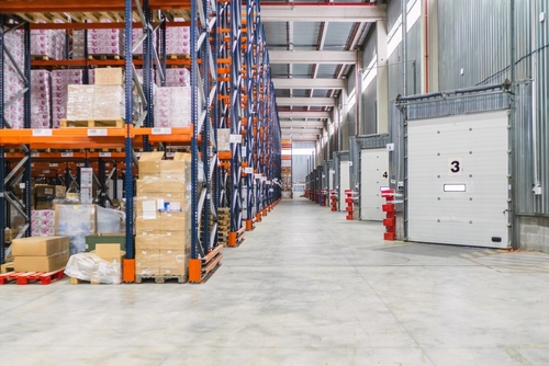 Warehouse operations with forklift and boxed inventory supported by apparel order management software