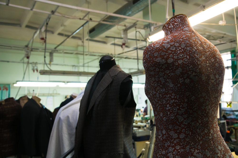 Garment production floor with dress forms and active sewing stations supported by PolyPM ERP inventory software for textile manufacturing from Polygon Software