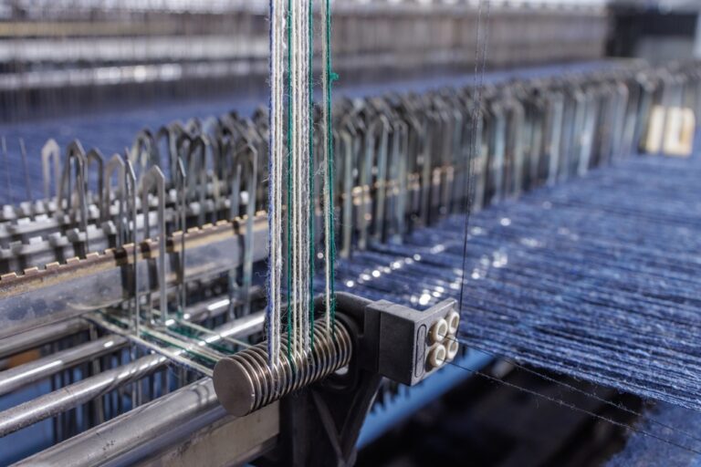 Garment manufacturing machine working inside a textile factory with apparel production software supporting production planning and quality control.