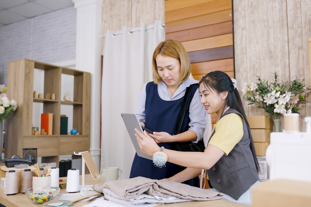 Apparel professionals reviewing fabric samples and production plans with apparel sourcing software supporting efficient supplier and material management.