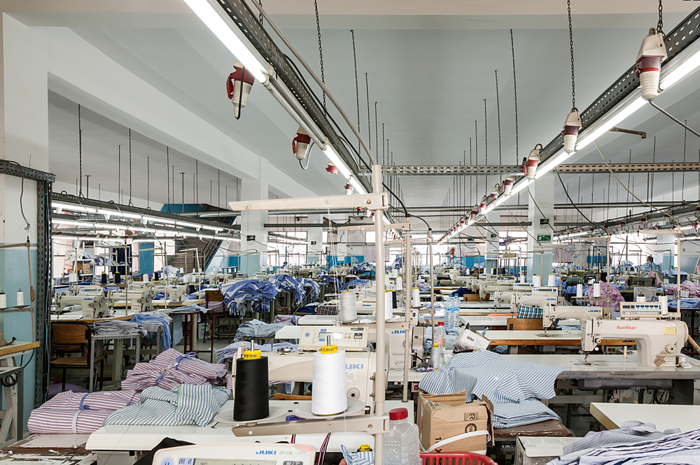 Industrial apparel manufacturing line featuring fabric cutting and sewing equipment supported by textile-erp-consulting solutions.