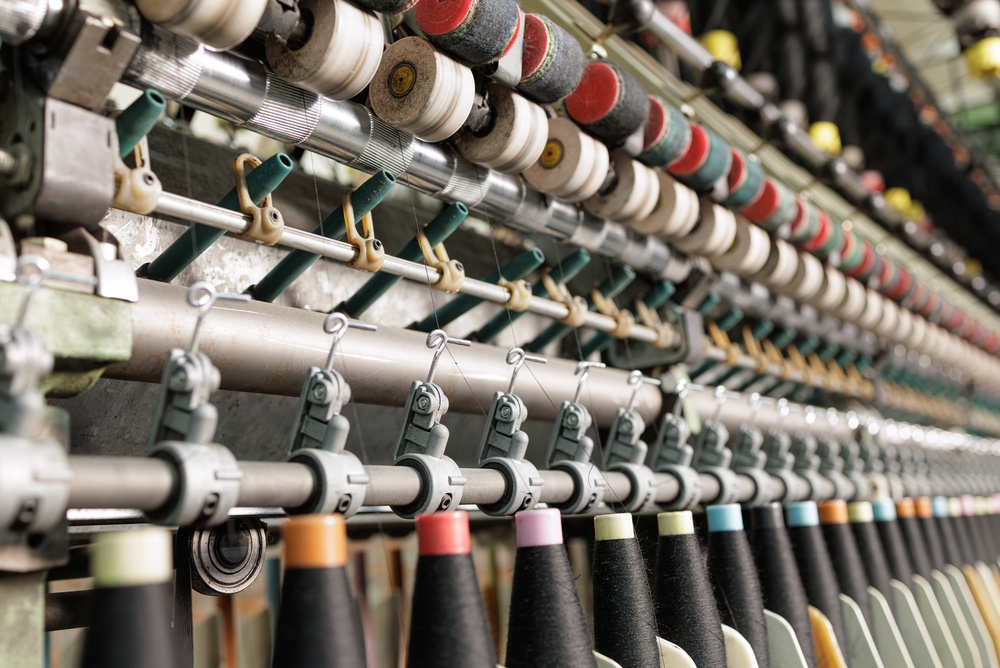 Textile factory producing garments with advanced equipment powered by apparel supply chain management software for efficient production planning and material management.