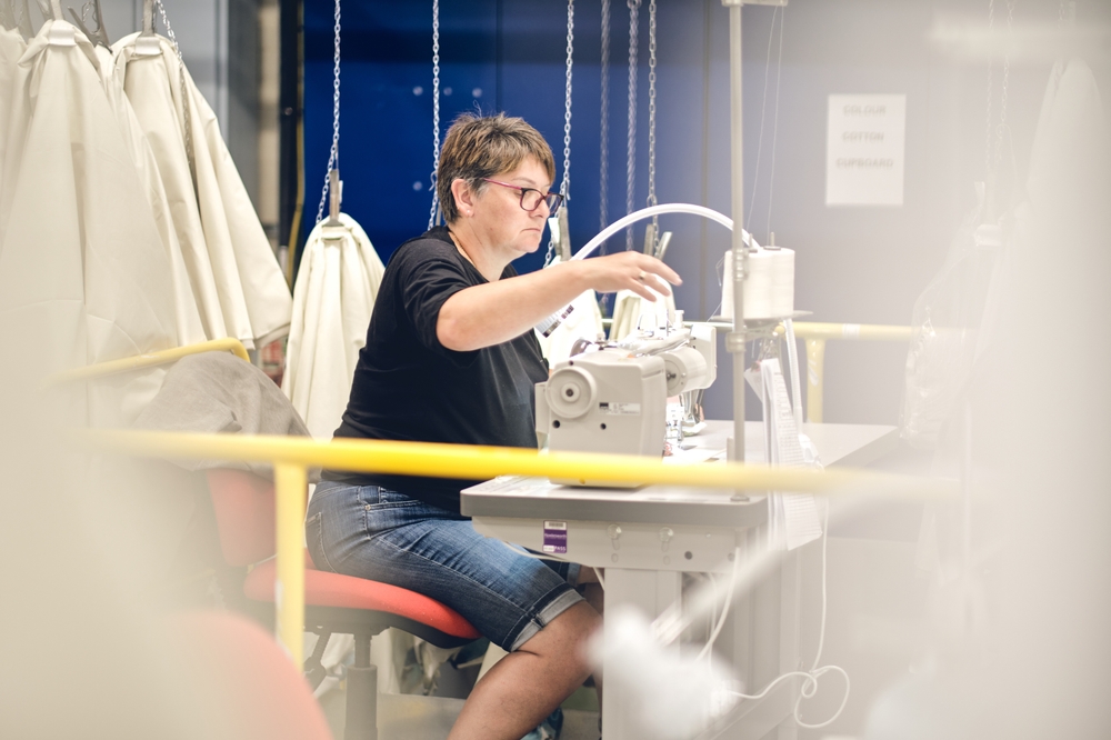 Apparel factory floor with workstations organized according to garment production scheduling software output