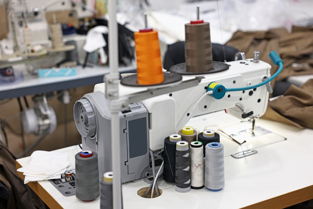 Close up of an industrial sewing machine that works in a production facility using garment production scheduling software