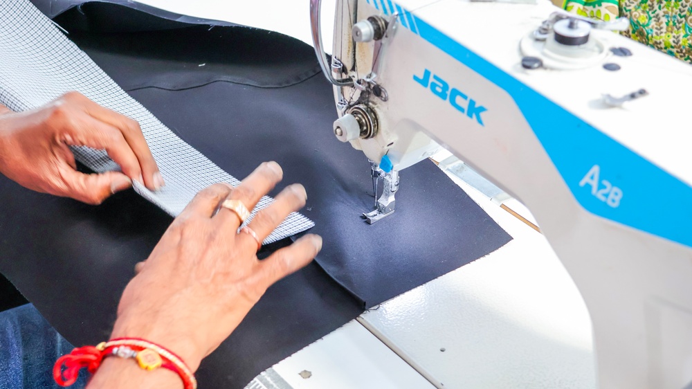Apparel quality control supervisor verifying consistency across fabric rolls
