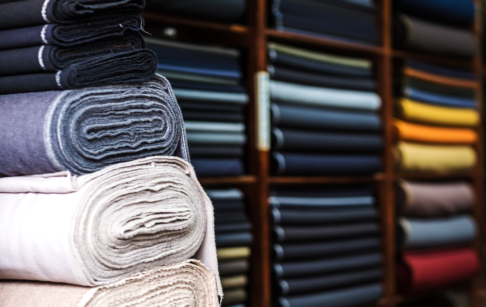 Rows of colorful textile rolls in a manufacturing facility managed with fabric roll tracking software
