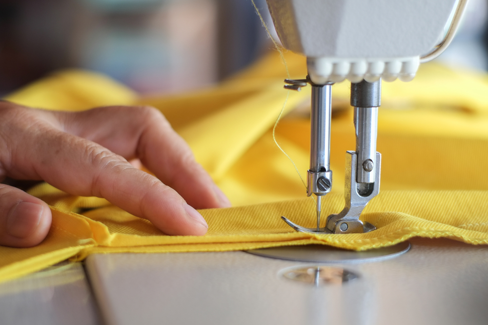 Industrial sewing machine in a garment factory supported by clothing manufacturing software